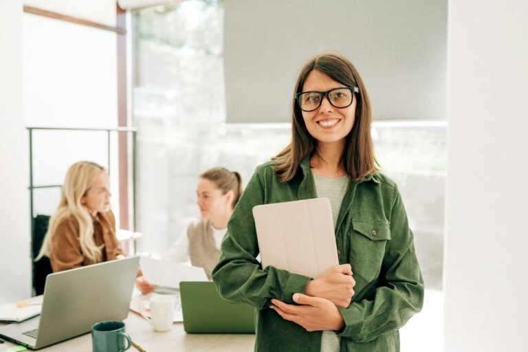 Portrait of a modern cosmopolitan business woman in glasses standing in the office.